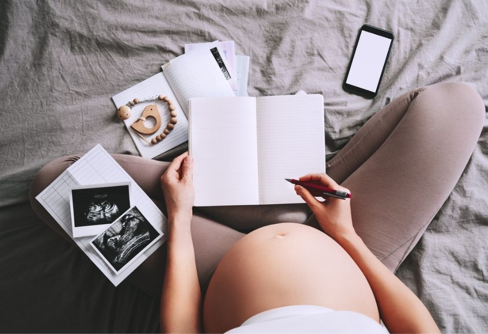 Schwangere Frau mit einem Buch in der Hand